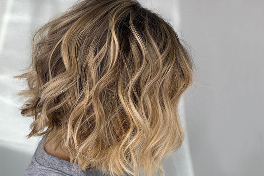Capelli medi con onde morbide realizzate con il ferro per creare volume e movimento.