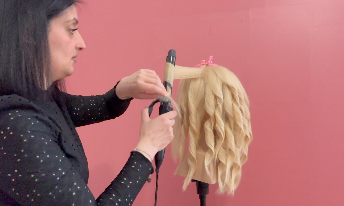 Hairstylist che si esercita nella creazione di onde con il ferro per migliorare la tecnica.