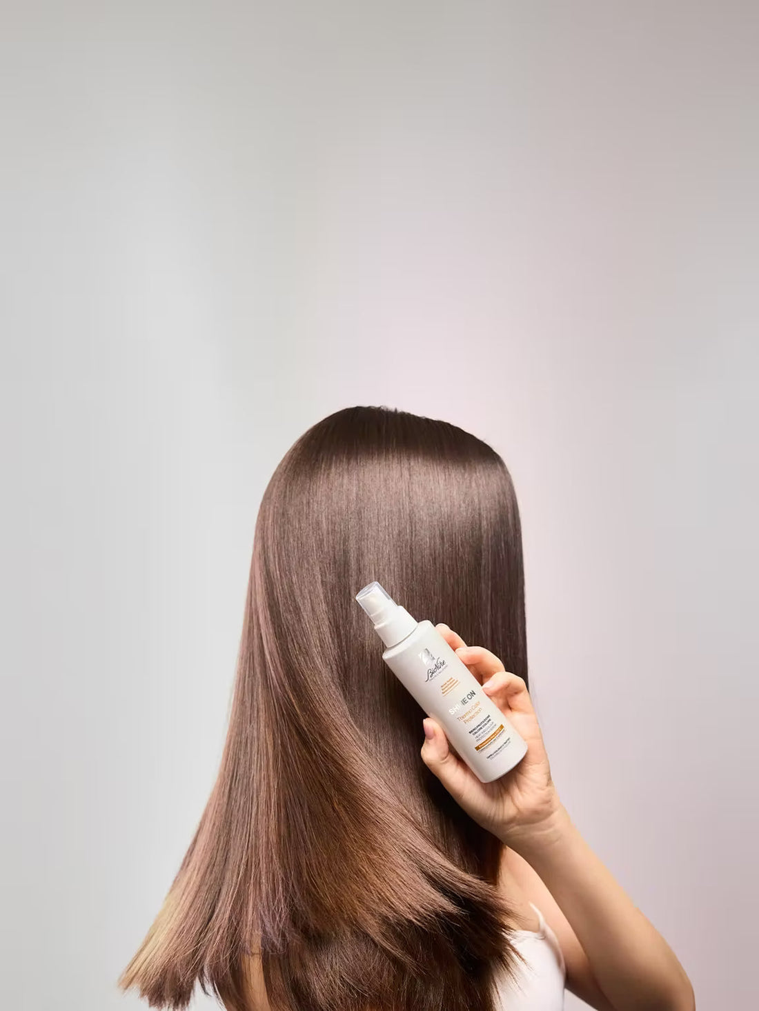 Capelli lisci, luminosi e morbidi dopo una corretta preparazione prima della piastra.