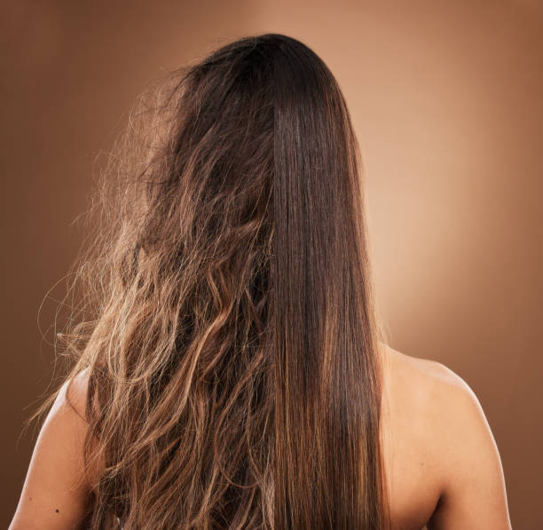 Hairstylist realizza un liscio perfetto su capelli crespi con una piastra professionale, ottenendo un risultato luminoso, morbido e senza effetto crespo.