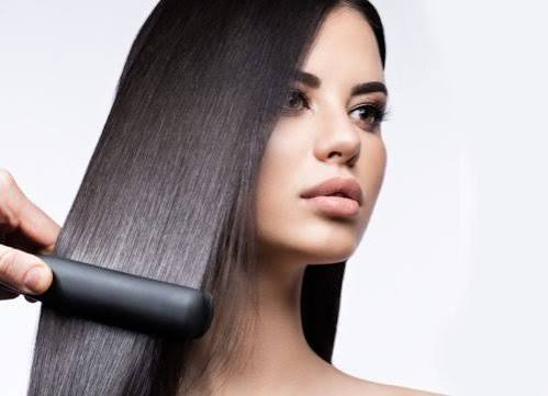 Capelli perfettamente lisci e luminosi realizzati con la piastra grazie a una tecnica professionale.