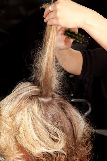 Acconciatura elegante e professionale con onde morbide e capelli ordinati.