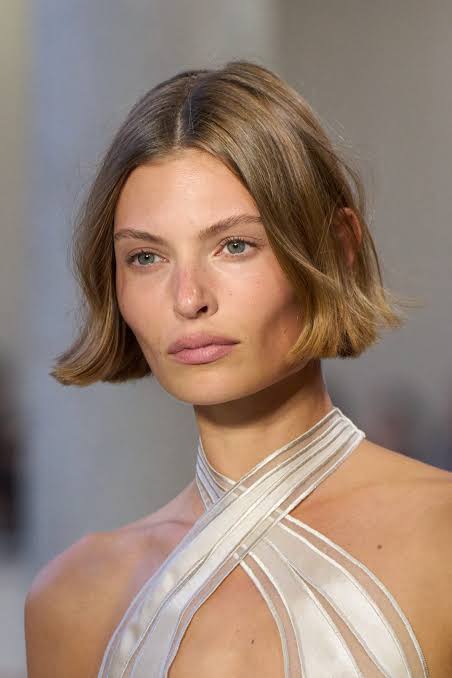 Capelli fini con onde morbide realizzate con il ferro per creare volume e movimento.