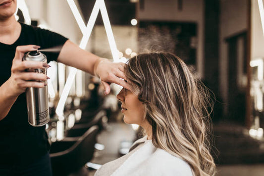 Professionista hairstylist durante la realizzazione di uno styling professionale sui capelli.