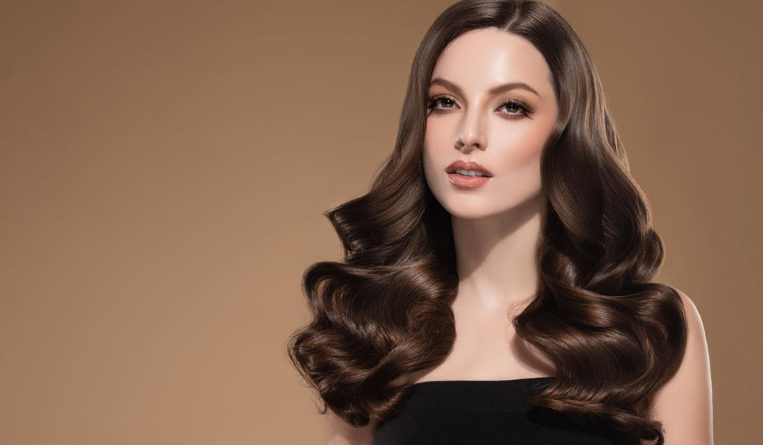 Donna con capelli castani lunghi e voluminosi, acconciati con onde morbide e piega professionale.