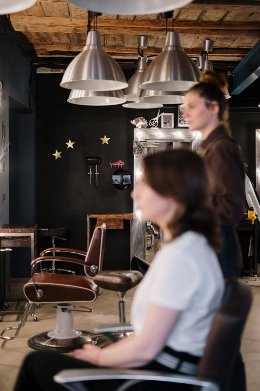 Professionista dell'acconciatura utilizza una piastra per creare un liscio perfetto e luminoso sui capelli.