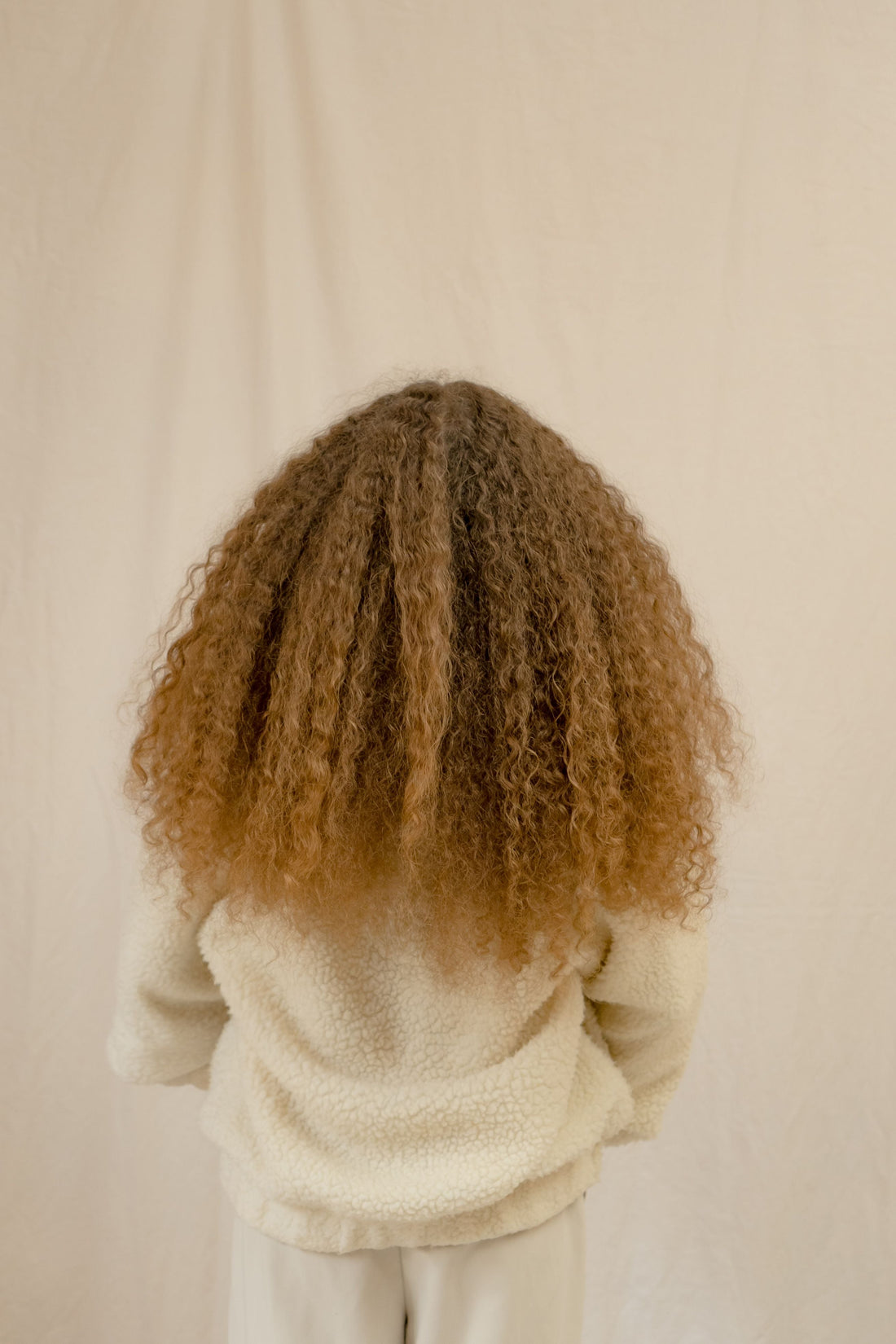 Hairstylist realizza un liscio perfetto su capelli ricci utilizzando una piastra professionale per eliminare il crespo e ottenere una piega liscia, luminosa e disciplinata.